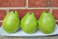 Three Pears on the white plate red brick backgroun Royalty Free Stock Photo