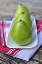 Three Pears on the white plate wooden background Royalty Free Stock Photo