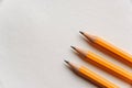 Three pencils lie in parallel on a blank piece of paper. Royalty Free Stock Photo