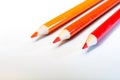 Three pencils on a white background. Red and orange colors. Creation. Art. Warm colors. Education. Back to school