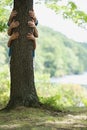 Three people behind tree