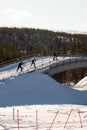 Three people crossing a bridge doing cross country ski