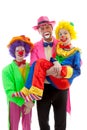 Three people dressed up as colorful funny clowns Royalty Free Stock Photo