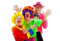 Three people dressed up as colorful funny clowns