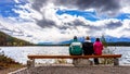 Three people enjoying the view of Pyramid Lake in Jasper National Park