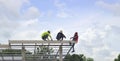 Three people installed eaves roof on steel truss, colored roof truss, bright sky background.copy space