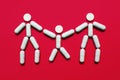 The shape of three little men from pills on a red background, the concept of family treatment and protection against disease Royalty Free Stock Photo