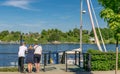 Three people next to a boat on a river.