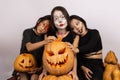 The three people are posing with painted faces for a Halloween-themed photo Royalty Free Stock Photo