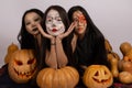 The three people are posing with painted faces for a Halloween-themed photo Royalty Free Stock Photo