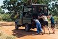 Three people pushing a car that stuck in the sand in savannah Royalty Free Stock Photo