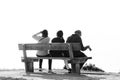 Three people rests on a wooden bench