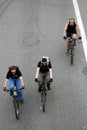 Three people ride bikes. View from above.