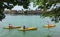 Three people rowing on a lake