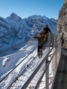 Three people walking on the Thrill Walk at Birg near Schiltorn in the Swiss Alps. It`s a steel pathway built into the mountainside Royalty Free Stock Photo