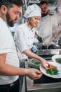 Three people woring together. Professional chef preparing food in the kitchen Royalty Free Stock Photo