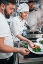 Three people woring together. Professional chef preparing food in the kitchen