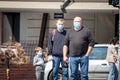 Three persons, including a father with his child boy, wearing a respiratory face mask in the streets of Belgrade