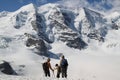 Three persons are watching on Swiss mountains