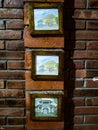 three photos hanging on a brick wall