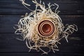 Three pialas in straw nest on black wooden desk
