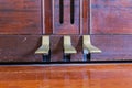 Three piano pedals on a wooden piano