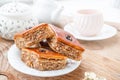 Three pieces of baklava with walnuts on a white plate, a teaspoon, a beautiful cup of tea, a teapot on a wooden table Royalty Free Stock Photo