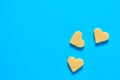 Three pieces of cheese in form of heart lies on blue desk on kitchen. Concept of Valentine`s Day