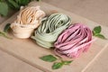 Three pieces of colorful raw italian fettuccine pasta with basil. Royalty Free Stock Photo