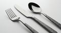 Three pieces of cutlery are arranged horizontally on a light surface. The set includes a Royalty Free Stock Photo