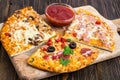 Three pieces of different pizzas on a wooden Royalty Free Stock Photo