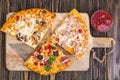 Three pieces of different pizzas on a wooden Royalty Free Stock Photo