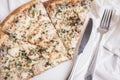 Three pieces of pizza on a white plate, a silver knife and fork Royalty Free Stock Photo