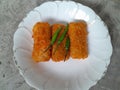 Three pieces of rissoles filled with chicken are served on a white plate.