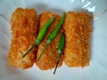 Three pieces of rissoles filled with chicken are served on a white plate.