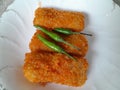 Three pieces of rissoles filled with chicken are served on a white plate.