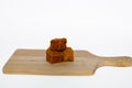three pieces of sumedang tofu (fried tofu) on a wooden board isolated on white