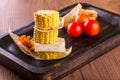 Three pieces of sweet corn with bread and tomatoes Royalty Free Stock Photo