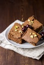 Three Pieces of Tasty Homemade Chocolate Brownies on White Plate Decorated with Cherry and Pistachios Wooden Background Homemade