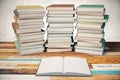 Three piles of books and blank diary in the middle on wooden tab