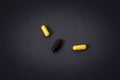 Three pills in capsules on a dark background.