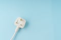 Three pin plug on light blue background with a copy space Royalty Free Stock Photo