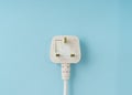 Three pin plug on light blue background with a copy space Royalty Free Stock Photo