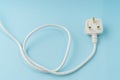 Three pin plug on light blue background with a copy space Royalty Free Stock Photo