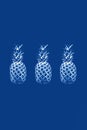 Three pineapples in monochrome on a blue background. Concept abstraction, surrealism, color of the year 2020, food