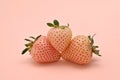 three pineberries on a peach background close-up Royalty Free Stock Photo