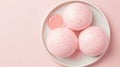 Three pink bath bombs with delicate bubbles sit on a white dish with a small amount of pink liquid. Royalty Free Stock Photo