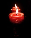 Three pink candles burning brightly on black background Royalty Free Stock Photo
