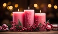 Three pink christmas candles with pine and holly decorated in autumnal colours Royalty Free Stock Photo