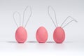Three pink Easter eggs, cute bunnies. Concept decoration for a Happy Easter. White isolated background with soft shadow Royalty Free Stock Photo